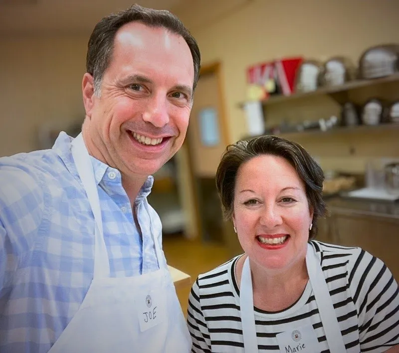 Joe and Marie Schick at King Arthur Baking, wearing aprons in a kitchen